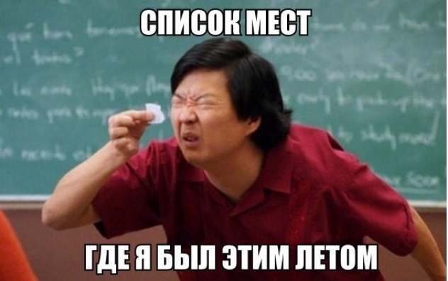 Мужчина с выражением недоумения пытается прочитать маленький листок бумаги на фоне школьной доски с надписью 'СПИСОК МЕСТ ГДЕ Я БЫЛ ЭТИМ ЛЕТОМ'.